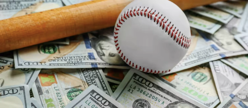 Stack of dollars with baseball bat and ball over them. Chicago man fights for $800K sports bets winnings.